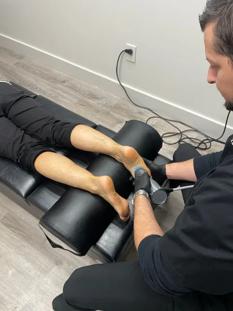 Dr. Brian Chinn performing shockwave therapy on a patient's foot